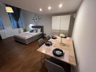 a bedroom with a bed and a table and chairs at Absolutum Apartments in Ljubljana