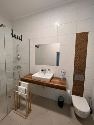 a bathroom with a sink and a shower and a toilet at Absolutum Apartments in Ljubljana