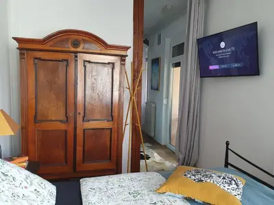 a bedroom with a wooden door next to a bed at Apartment with Terrace Nona Pavla in Tolmin