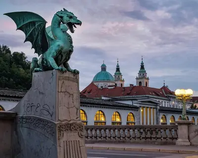 a statue of a dragon in front of a building at Center Station ROOMS in Ljubljana