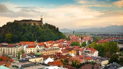 a city with a castle on top of a hill at Center Station ROOMS in Ljubljana