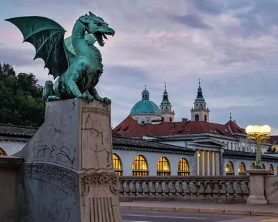 a statue of a dragon in front of a building at Center Station ROOMS in Ljubljana