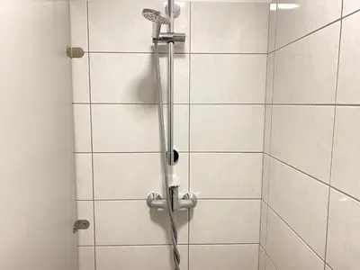 a shower with a shower head in a bathroom at Center Station ROOMS in Ljubljana