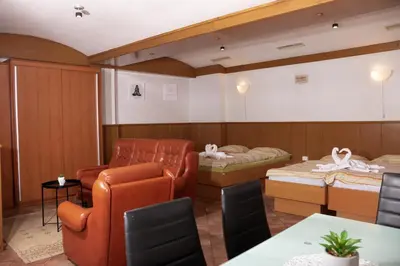 a room with two beds and a table and chairs at Apartma-studio Ajdna in Žirovnica