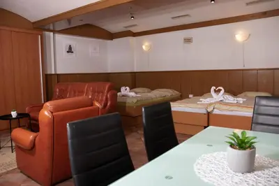 a room with two beds and a table and chairs at Apartma-studio Ajdna in Žirovnica