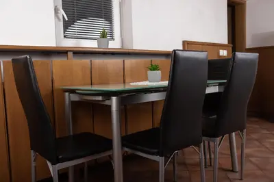 a table with four black chairs at a restaurant at Apartma-studio Ajdna in Žirovnica