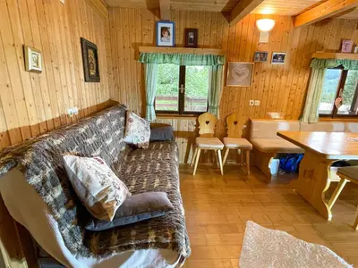a living room with a couch and a table at Dwarfs cabin overlooking Julian Alps near Bled in Jesenice
