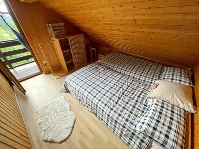 a room with a bed in a wooden cabin at Dwarfs cabin overlooking Julian Alps near Bled in Jesenice