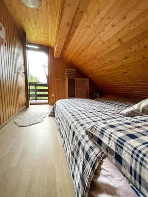 a bedroom with a bed in a wooden room at Dwarfs cabin overlooking Julian Alps near Bled in Jesenice