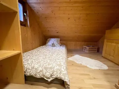 a bedroom with a bed in a wooden attic at Dwarfs cabin overlooking Julian Alps near Bled in Jesenice