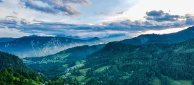 a view of a valley with trees and mountains at Dwarfs cabin overlooking Julian Alps near Bled in Jesenice