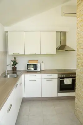 a kitchen with white cabinets and a sink and a microwave at Sofia Holiday Haven in Nature with Pool in Slovenska Bistrica