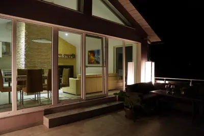 a living room with sliding glass doors and a table at Sofia Holiday Haven in Nature with Pool in Slovenska Bistrica
