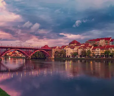 a bridge over a river in a city with buildings at Sofia Holiday Haven in Nature with Pool in Slovenska Bistrica