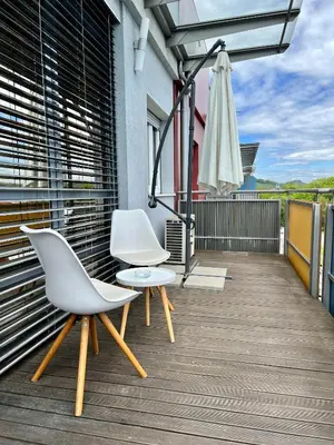 two white chairs and a table on a balcony at Condo Casa Di Olivia in Maribor