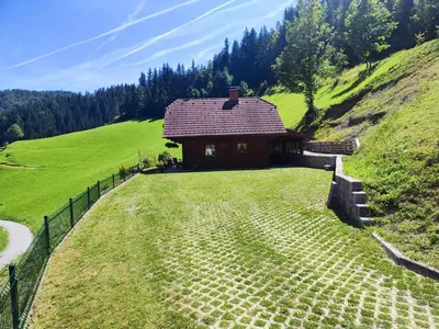a small house on a hill with a grass field at Počitniška hišica Rogatec - Holiday Cottage Rogatec in Luče