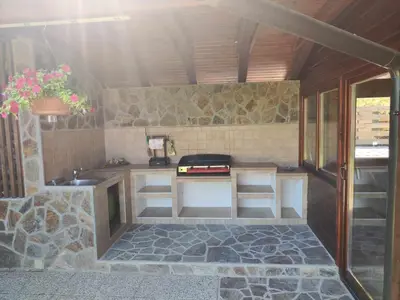 a small kitchen with a stove and a sink at Počitniška hišica Rogatec - Holiday Cottage Rogatec in Luče