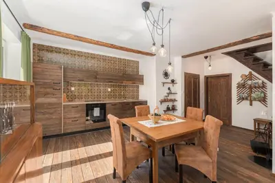 a dining room with a wooden table and a fireplace at DoLodge Homestead & Camper Parking Kolpa River Canyon in Stari Trg ob Kolpi